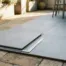 Keramische 60x60 tegels met matte betongrijs glazuur in strak gridpatroon op buitenterras, dunne voegen en scherpe randen zichtbaar.